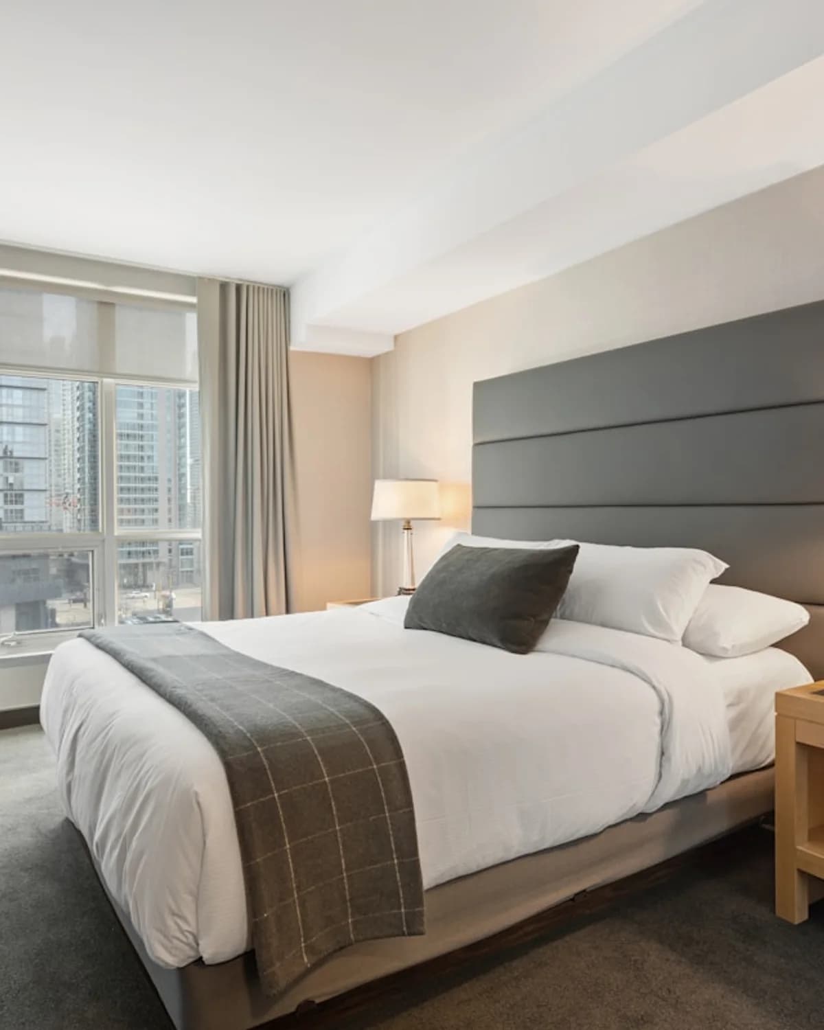Striped hotel bedding in a calm bedroom